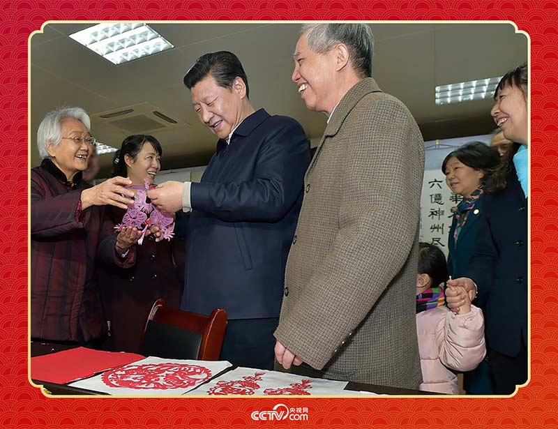 2015年2月15日，习近平在西安市雁塔区电子城街道二〇五所社区服务中心欣赏社区居民的剪纸作品。